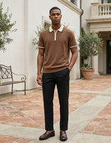 Man wearing a brown polo shirt and black pants standing in an outdoor setting.