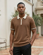 Man wearing a brown short-sleeve sweater with white trim in an outdoor setting.