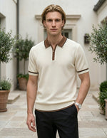 Man wearing a cream polo shirt with brown accents standing outdoors.