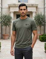 Man wearing a green t-shirt with a logo in an outdoor setting