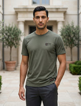Man wearing a green t-shirt with a logo in an outdoor setting