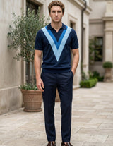 Man wearing a navy blue polo shirt with a light blue V-neck design and dark pants, standing in an outdoor setting.