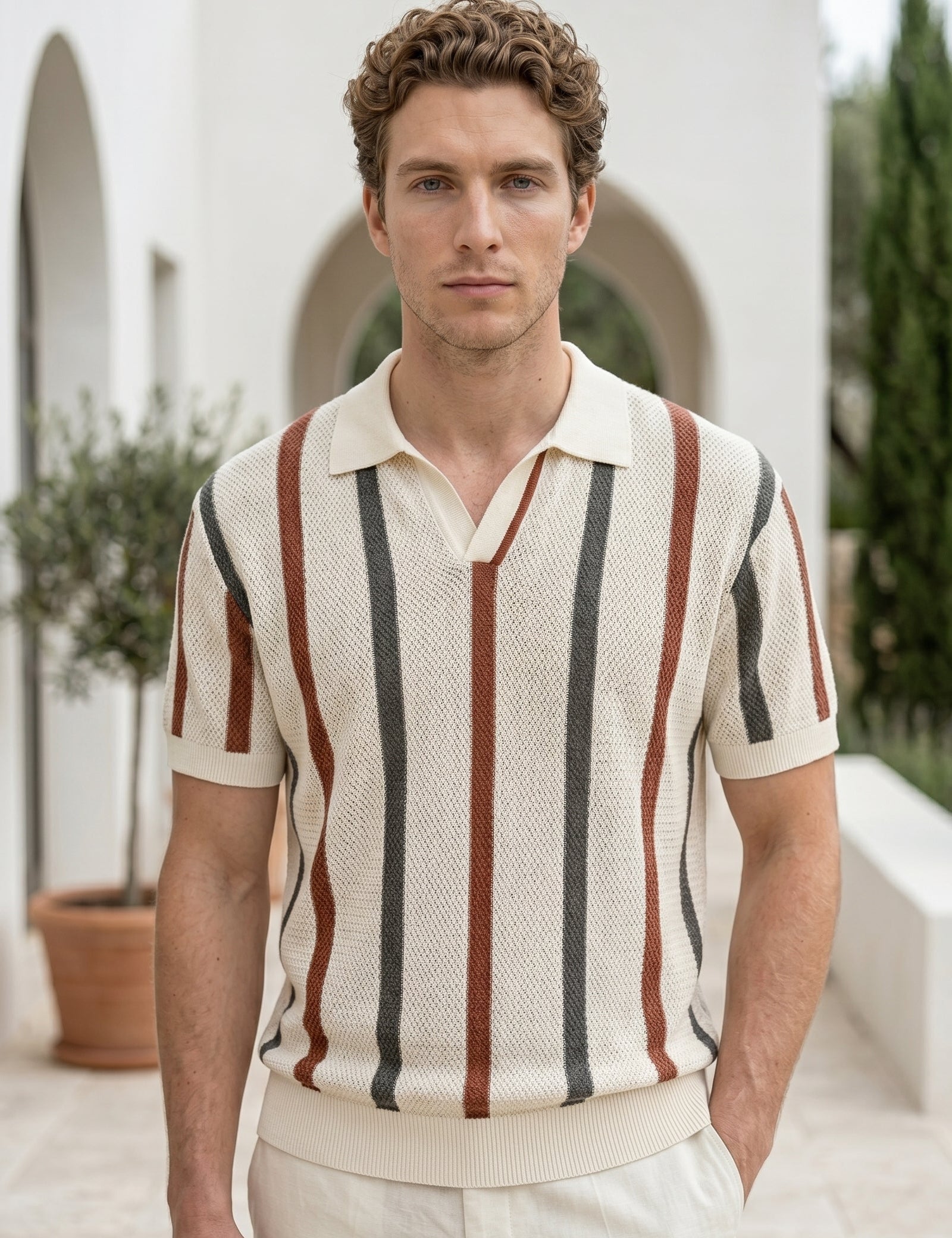 Man wearing a striped polo shirt in an outdoor setting