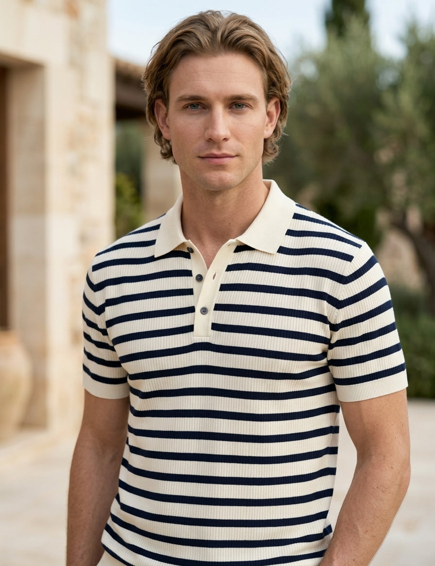 Man wearing a striped polo shirt outdoors with a blurred background