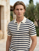 Man wearing a striped polo shirt outdoors with a blurred background