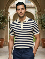 Man wearing a striped polo shirt standing in an outdoor setting with arches and plants.