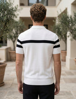 Man wearing a white polo shirt with black stripes outdoors