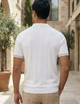 Man wearing a white polo shirt and beige pants, rear view