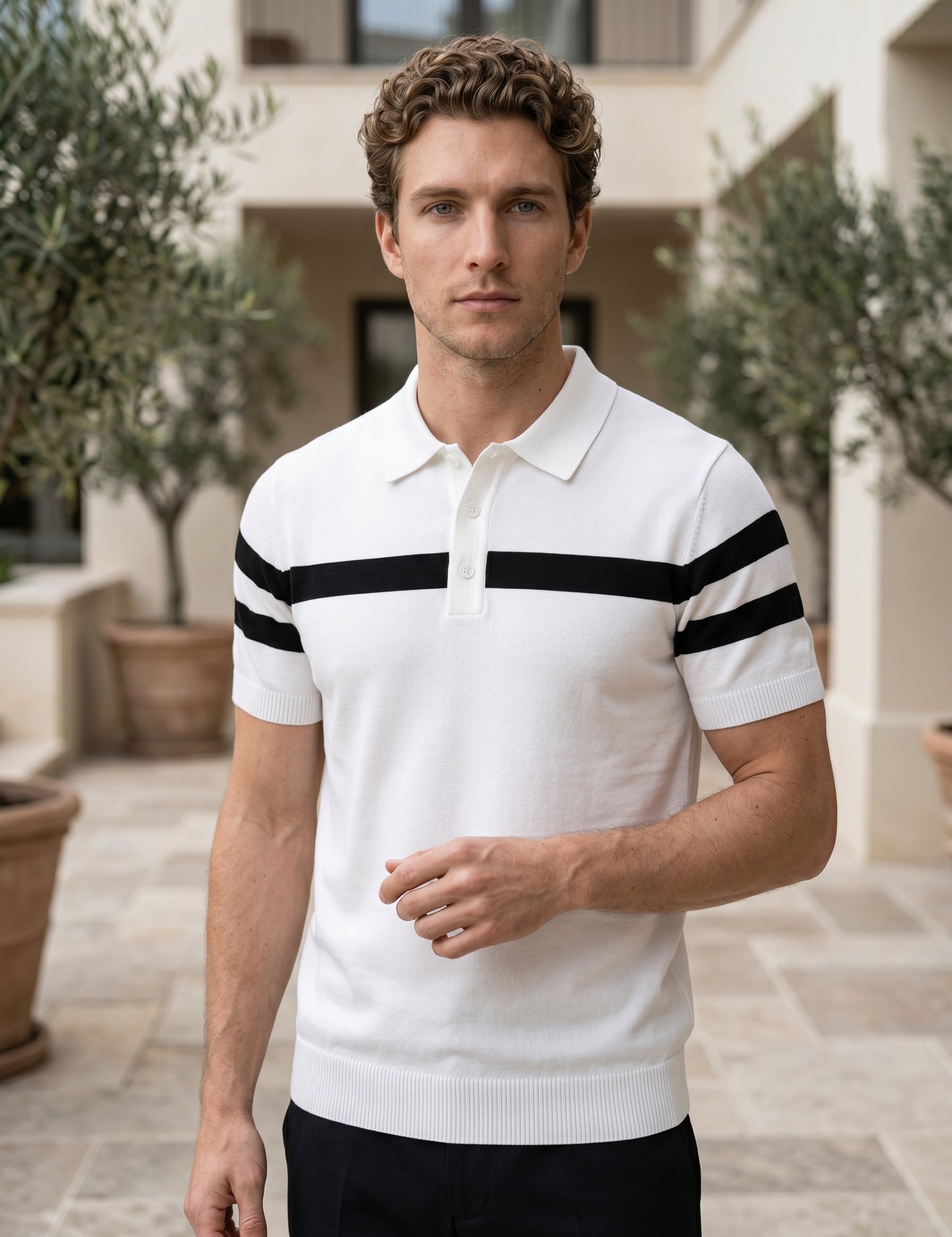 Man wearing a white polo shirt with black stripes outdoors