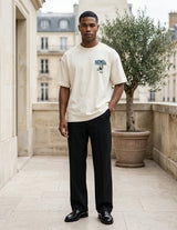 Man wearing a white t-shirt with a graphic design in an urban setting