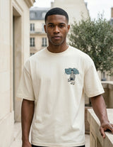 Man wearing a white t-shirt with a graphic design in an urban setting