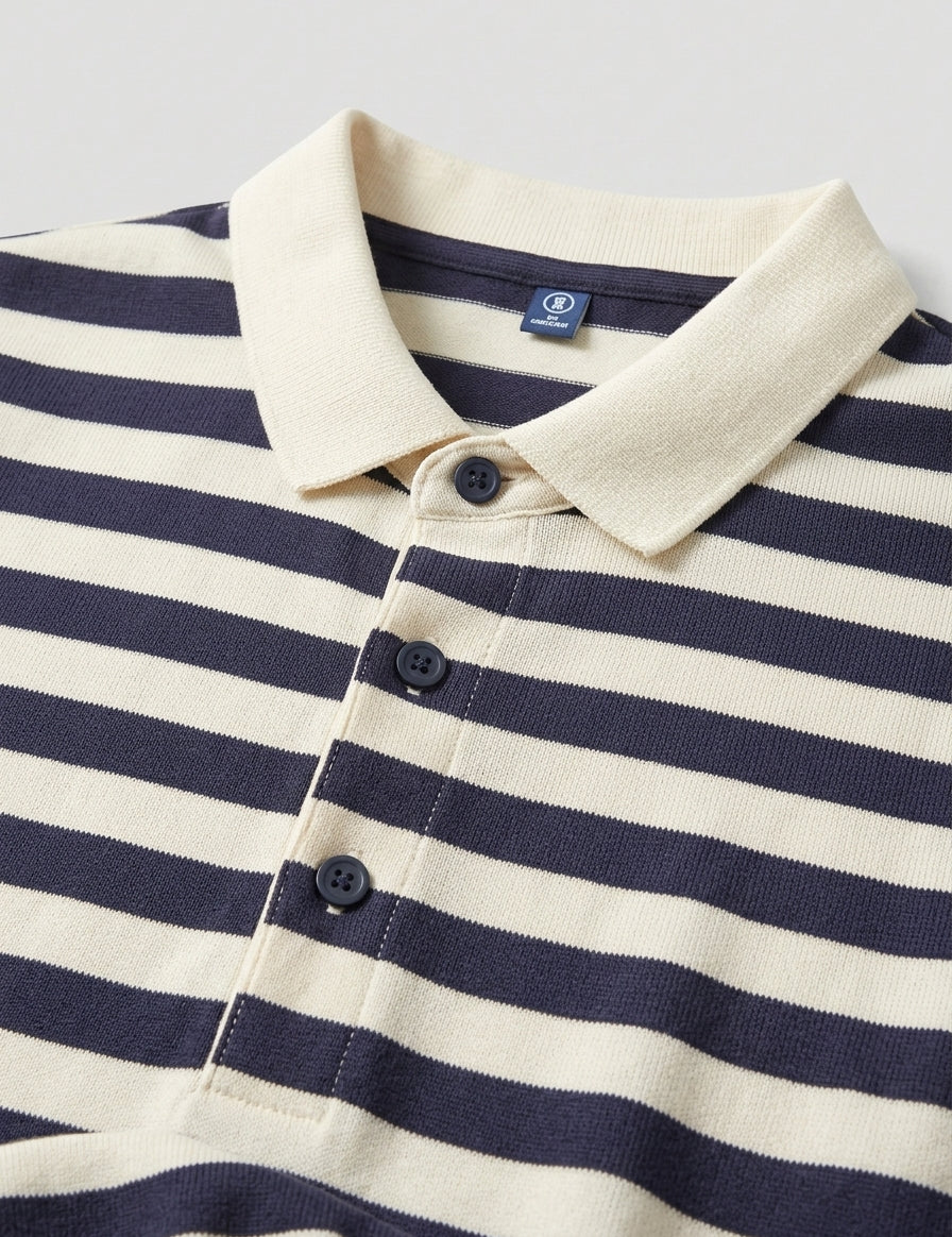Navy and white striped polo shirt with a close-up of the collar and buttons on a light gray background.
