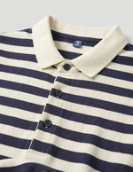 Navy and white striped polo shirt with a close-up of the collar and buttons on a light gray background.