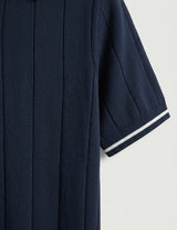 Navy blue coat with white trim on a light gray background