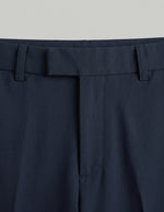 Navy blue pants with a belt on a light gray background