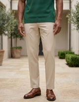 Person wearing a green shirt, beige pants, and brown shoes standing outdoors.