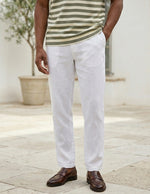 Person wearing a striped shirt, white pants, and brown shoes outdoors.
