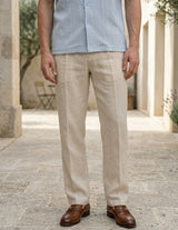 Person wearing beige pants and a light blue shirt outdoors on a stone path.