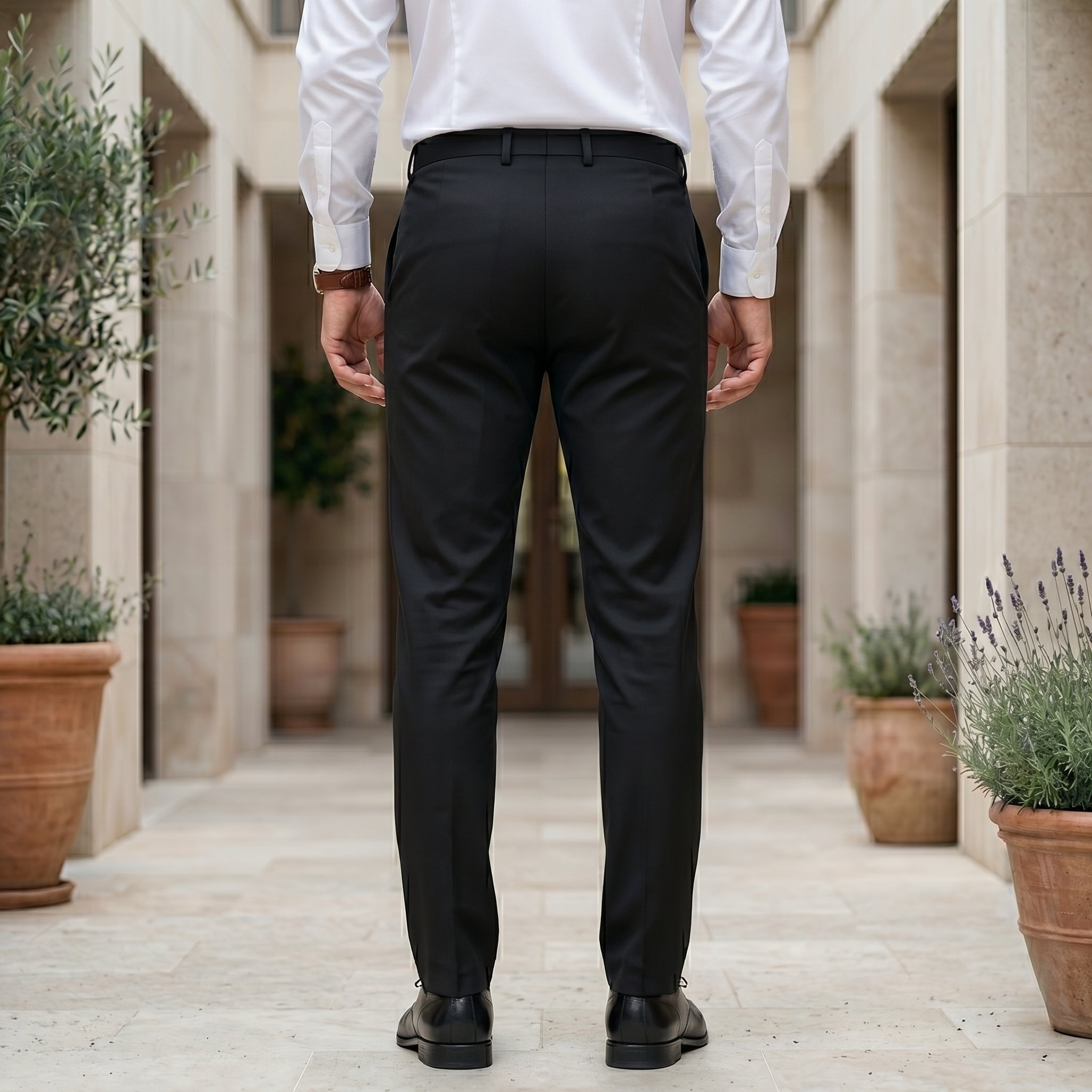 Person wearing black pants and a white shirt in an outdoor back view pant.