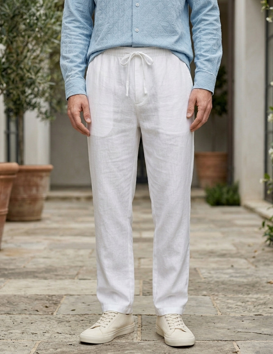 Person wearing light blue shirt and white pants standing outdoors on a wooden deck.