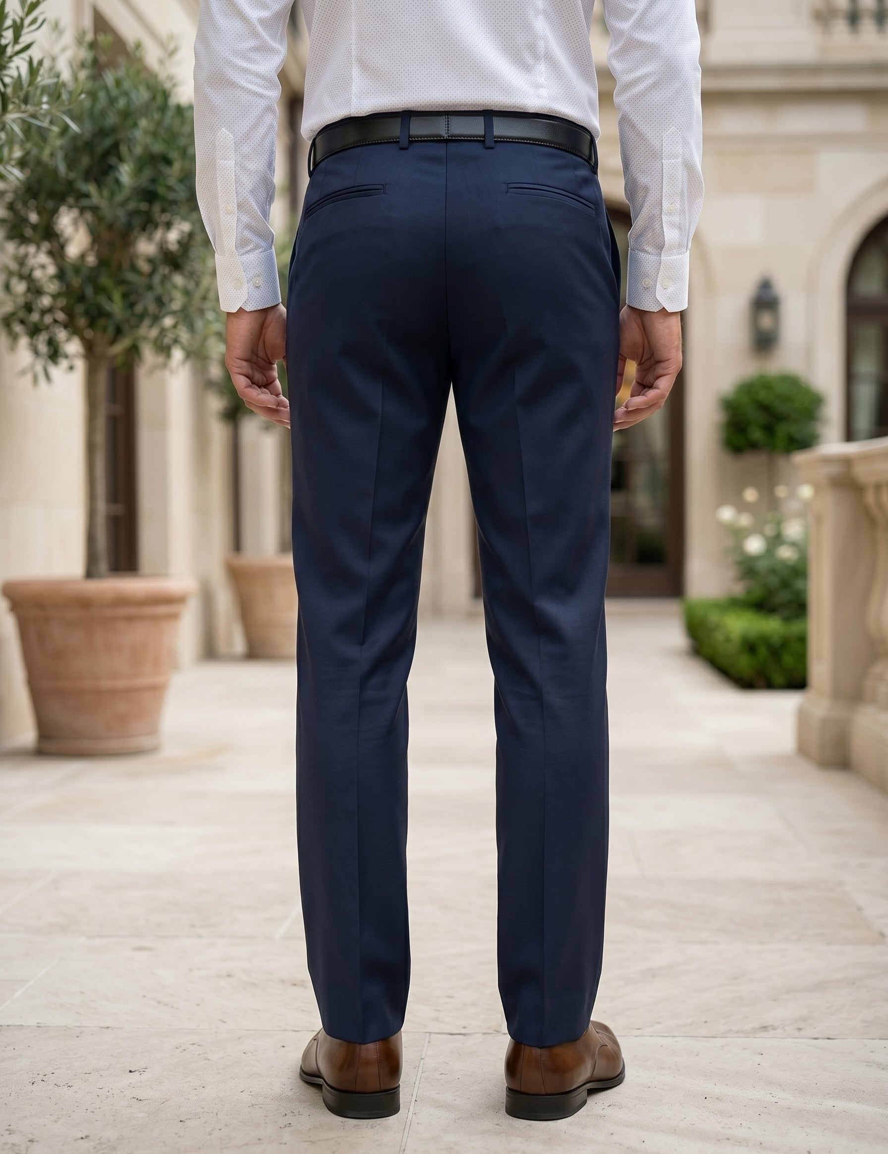 Person wearing navy pants and a white shirt in an outdoor setting