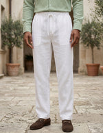 Person wearing white linen pants and a green shirt in an outdoor setting.