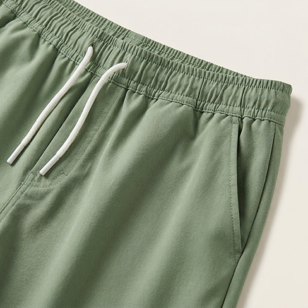 Green shorts with a white drawstring on a light background