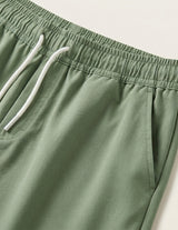 Green shorts with a white drawstring on a light background