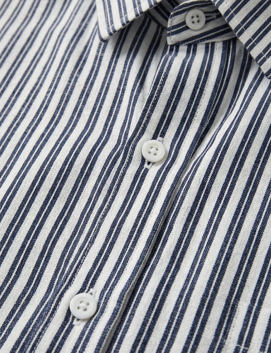 Close-up of a blue and white striped shirt with buttons.