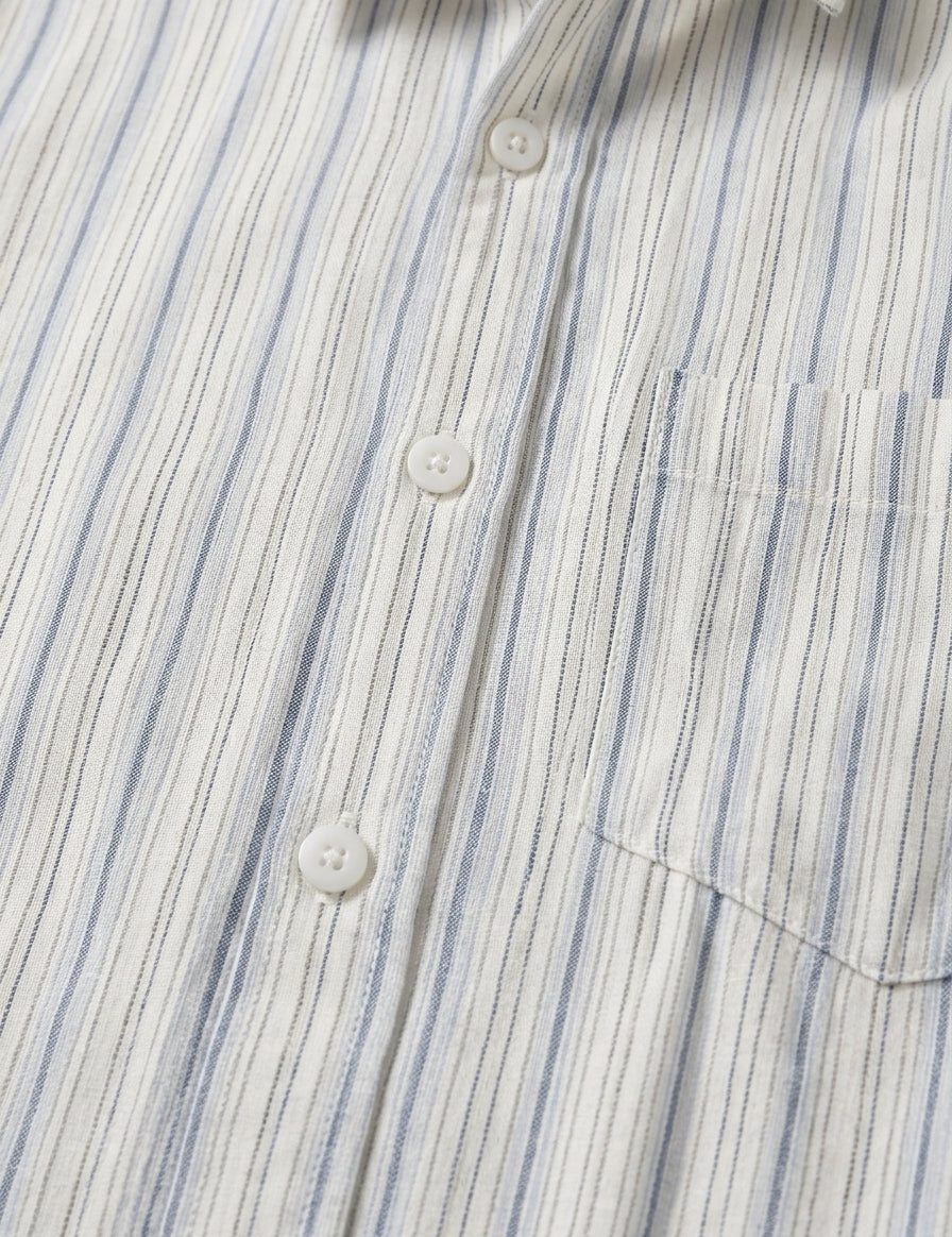 Close-up of a striped shirt with blue and white vertical lines.