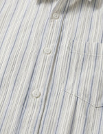 Close-up of a striped shirt with blue and white vertical lines.