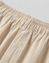 Close-up of beige fabric with an elastic waistband on a light gray background