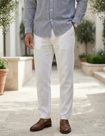 Person wearing a striped shirt, white pants, and brown shoes outdoors.