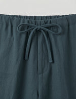 Teal pants with a drawstring waist on a light gray background
