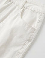 White men’s ribbed straight-leg trousers with pockets and button waistband close-up