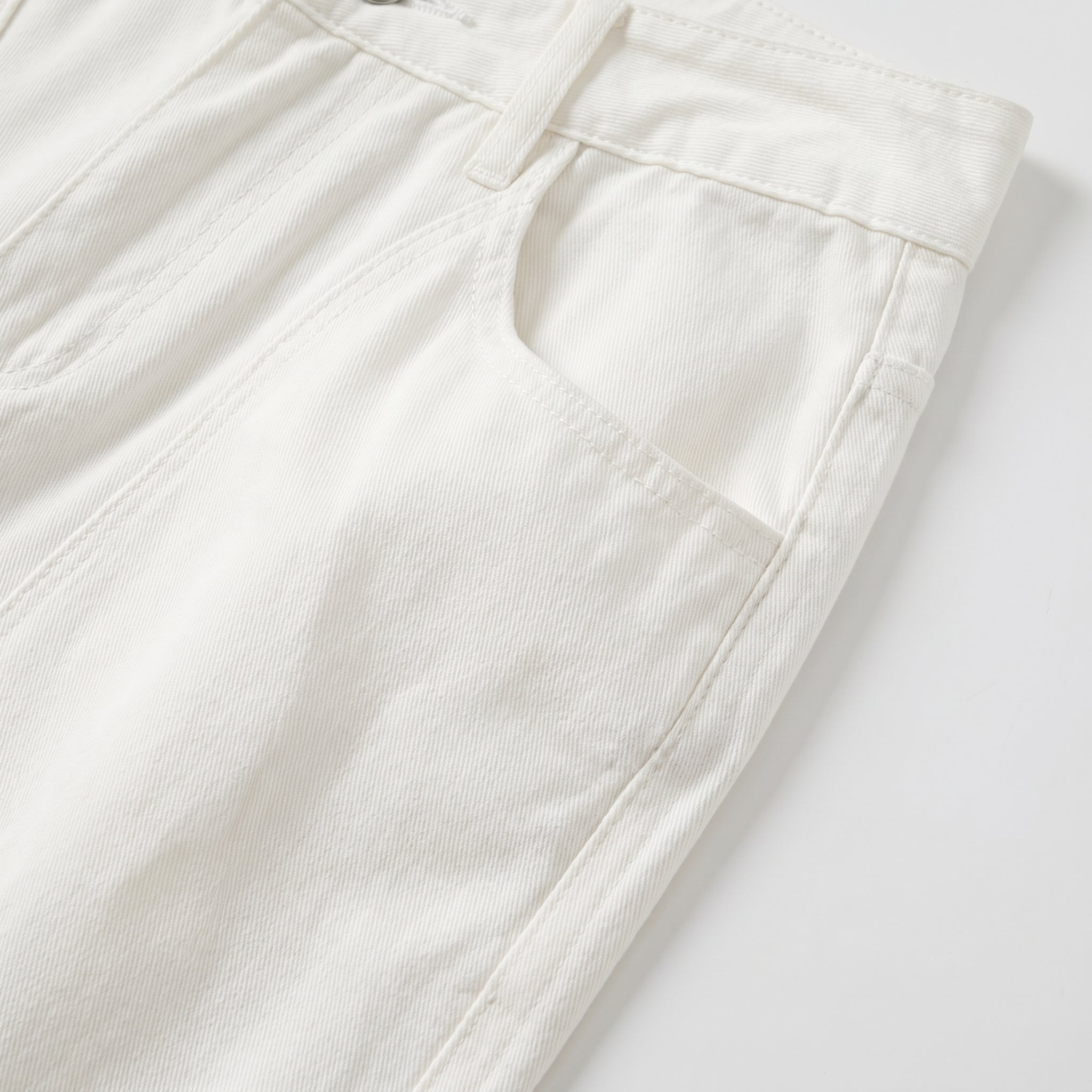 White men’s ribbed straight-leg trousers with pockets and button waistband close-up