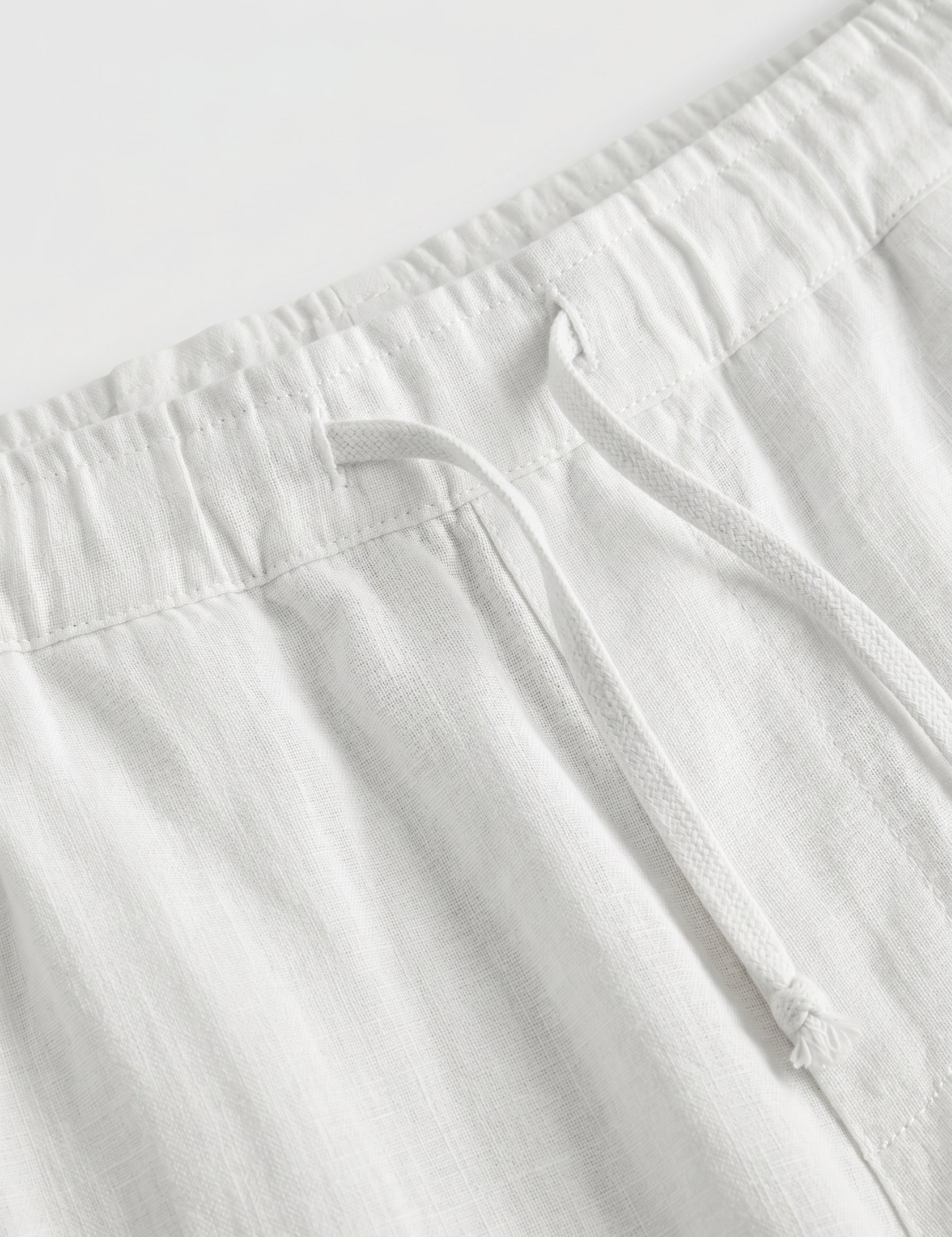 White pants with a belt on a white background