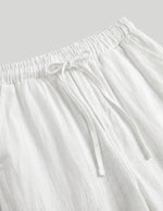 White pants with drawstring waist on a light gray background
