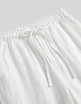 White pants with drawstring waist on a light gray background