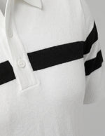 White sweater with black stripes on the sleeves against a light gray background