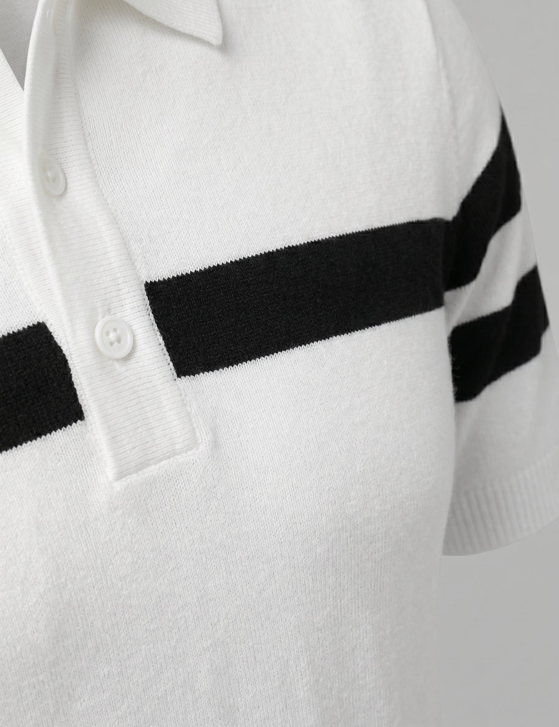 White sweater with black stripes on the sleeves against a light gray background