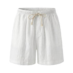 White textured drawstring summer shorts with elastic waistband and beige rope tie on a white background.