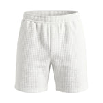 White textured summer shorts with elastic waistband on a white background.