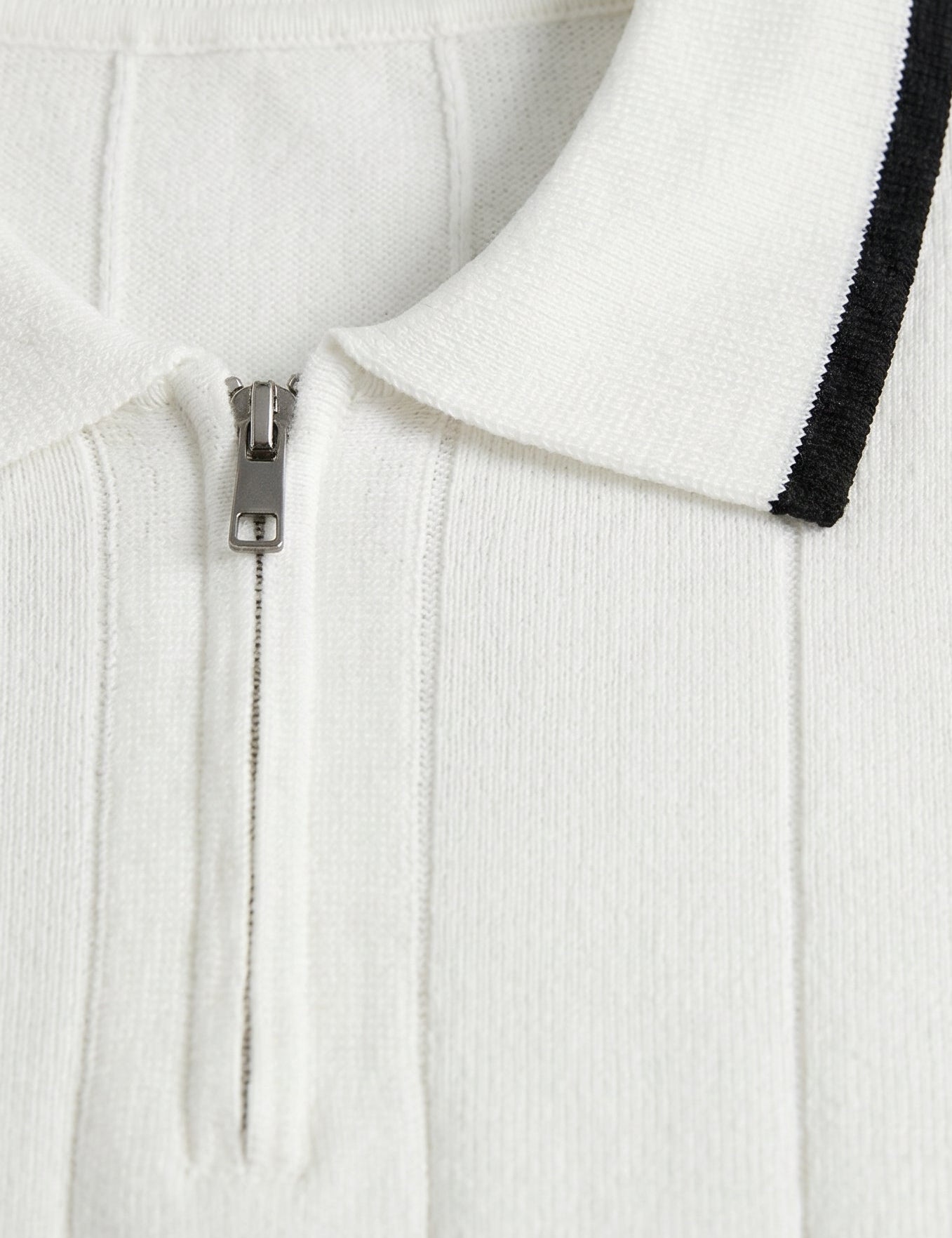 White zip-up hoodie with black trim on a light gray background