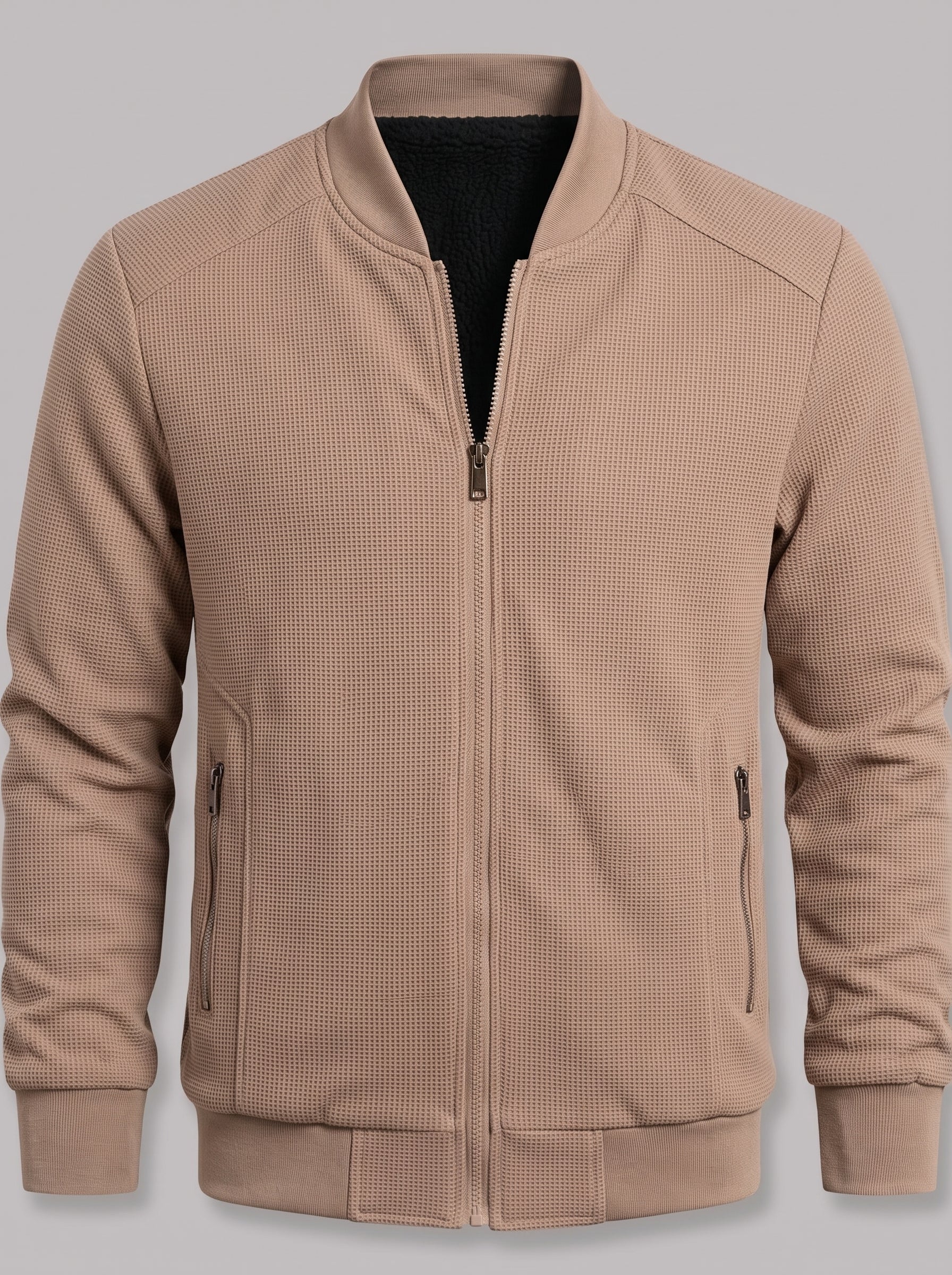 A men's waffle-knit zip-up jacket in a warm tan or camel color, featuring a ribbed collar, cuffs, and hem, with a black inner lining visible at the neckline.