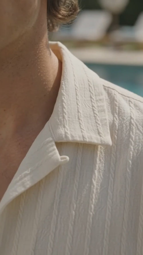 Model wearing an ivorry shirt in a video